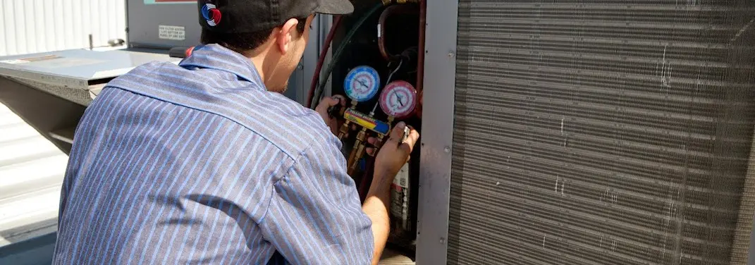 HVAC technician servicing a condenser unit in Allen