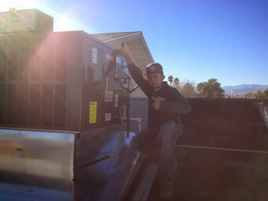 HVAC technician performing AC Tune-Up on a rooftop unit in Allen